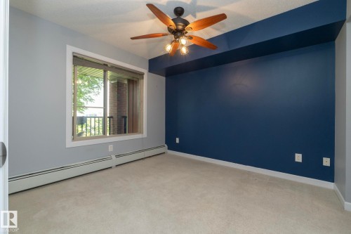 Room featuring light-colored carpet flooring and a ceiling fan with light fixture - 208 3719 Whitelaw Lane, Edmonton, AB 
