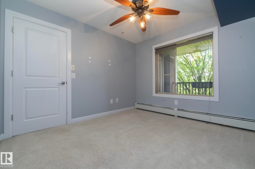 Light gray wall paint, off-white carpet flooring, and a ceiling fan with light fixture - 208 3719 Whitelaw Lane, Edmonton, AB 