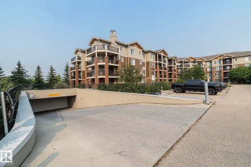 Multi-story residential building featuring balconies with black railings and brick accents - 208 3719 Whitelaw Lane, Edmonton, AB 