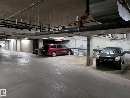 Underground parking garage featuring concrete flooring and exposed overhead utilities - 208 3719 Whitelaw Lane, Edmonton, AB 