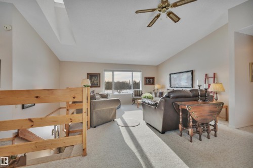 Living room with lofted ceiling, carpet flooring, and a ceiling fan - A49375 Rr 243, Rural Leduc County, AB 