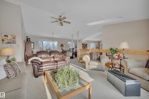 Carpeted living room with ceiling fan and a chandelier - A49375 Rr 243, Rural Leduc County, AB 