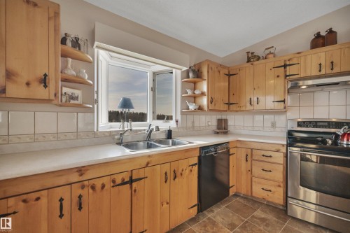Kitchen featuring open shelves, stainless steel range with electric stovetop, decorative backsplash, light countertops, and under cabinet range hood - A49375 Rr 243, Rural Leduc County, AB 