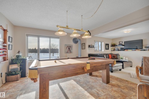 Rec room featuring pool table, stone finish floors, and a textured ceiling - A49375 Rr 243, Rural Leduc County, AB 