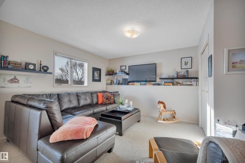 Living area with carpet flooring and a textured ceiling - A49375 Rr 243, Rural Leduc County, AB 