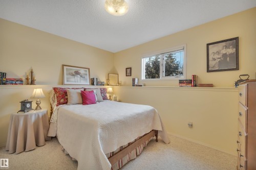 Carpeted bedroom featuring a textured ceiling and baseboards - A49375 Rr 243, Rural Leduc County, AB 