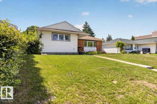 Exterior featuring white siding and brick accents with a gabled roofline - 10736 48 Street Nw, Edmonton, AB - Outdoor