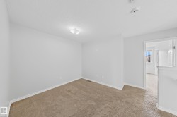 Carpeted room featuring white walls, white baseboards, and a flush-mount ceiling light fixture - 
