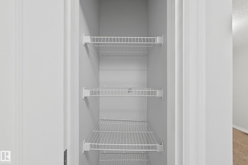 White wire shelving system within a recessed closet, featuring multiple adjustable shelves - 1806 28 Street Nw, Edmonton, AB 