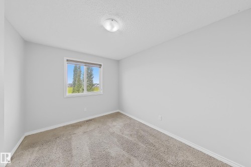 Bedroom with neutral carpeting and light-colored walls - 1806 28 Street Nw, Edmonton, AB 