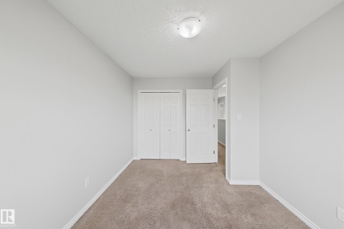 Neutral-toned carpeting and light gray walls create a versatile interior - 1806 28 Street Nw, Edmonton, AB 