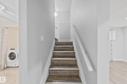 Staircase with wood-finish treads and white risers, featuring a white handrail - 
