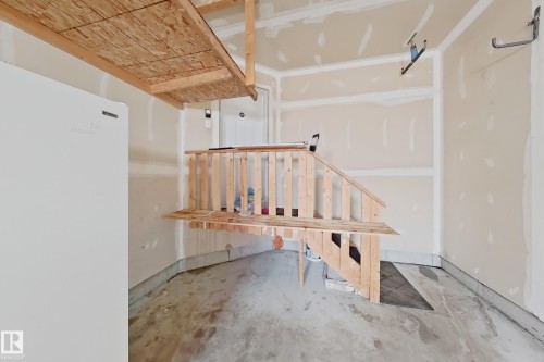 Garage featuring a concrete floor, built-in wooden storage shelves, and a high-mounted overhead storage platform - 1806 28 Street Nw, Edmonton, AB 