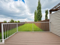 Spacious outdoor deck featuring composite decking and white metal railings - 