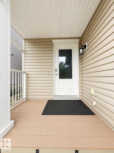 Covered front porch featuring composite decking, white column, and white railing - 1806 28 Street Nw, Edmonton, AB 
