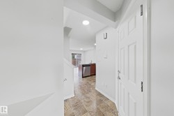 Entryway featuring a paneled white door, patterned tile flooring, and recessed lighting - 