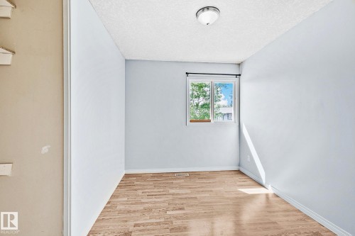 Room with wood-finish flooring, a window featuring a black curtain rod, and a semi-flush mount ceiling light - 17059 98 Street, Edmonton, AB - Indoor Photo Showing Other Room