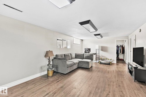 Spacious living area featuring wood-finish flooring, recessed lighting, and crisp white baseboards - 17059 98 Street, Edmonton, AB - Indoor