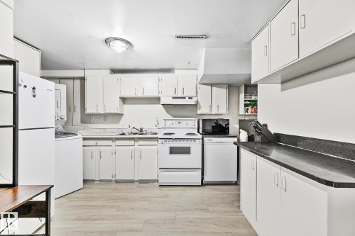 Kitchen featuring wood-finish flooring, white cabinetry, and dark countertops - 17059 98 Street, Edmonton, AB - Indoor Photo Showing Kitchen