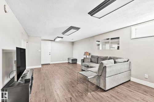 Spacious room featuring wood-finish flooring, light gray walls, and recessed ceiling lighting - 17059 98 Street, Edmonton, AB - Indoor