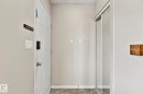Entryway featuring a paneled door with smart lock hardware, a sliding mirrored closet door, and gray-toned flooring - 17059 98 Street, Edmonton, AB  - Indoor Photo Showing Other Room 