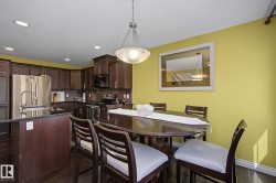 Kitchen and dining area featuring dark wood-finish flooring - 