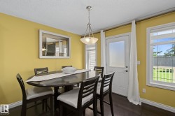 Dining area featuring wood-finish flooring, a white trim baseboard, and a ceiling-mounted light fixture - 