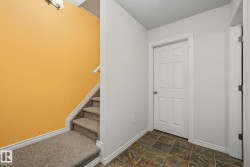 Carpeted staircase with white handrail and baseboards - 