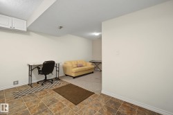 Flexible multi-purpose room featuring a combination of tile and carpet flooring, neutral paint, and built-in white cabinetry - 