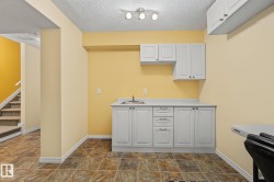 Built-in cabinetry with a sink, light countertops, and track lighting - 