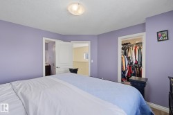 Bedroom featuring a ceiling-mounted light fixture, light purple wall paint, and carpeted flooring - 