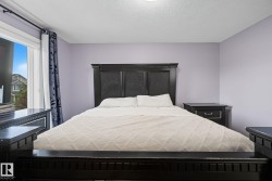 Spacious room with a large window, light purple walls, and a textured ceiling - 
