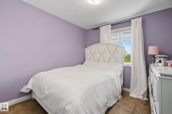 Bedroom featuring light purple walls, a window with white blinds, white window treatments, and carpet flooring - 