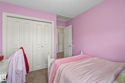 Carpeted room featuring a double bifold closet with panel doors, textured ceiling, and a white interior door - 