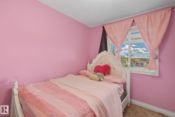 Room featuring a window with white trim, light pink walls, and a textured ceiling - 