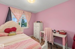 Bedroom featuring a window with exterior views, light pink walls, and a ceiling-mounted light fixture - 