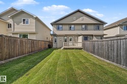 Private backyard featuring a wooden deck, expansive lawn, and full privacy fencing - 