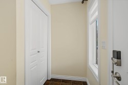 Entryway featuring light-toned walls, tile flooring, and a window with a roller shade - 