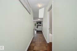Entryway featuring square brown floor tiles, light green wall paint, white baseboards, and a semi-flush mount ceiling light - 