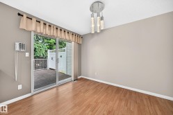 Hardwood-finish flooring extending to a sliding glass door leading to a deck - 