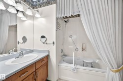 Bathroom vanity featuring a light-toned countertop with an integrated sink and wood-finish cabinetry - 