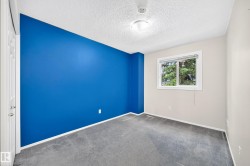 Room with gray carpeting, white trim, and a single window featuring exterior tree views - 