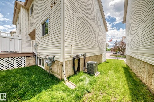 Cream-colored vinyl siding exterior with an elevated deck featuring white railings - 51 9630 176 Street, Edmonton, AB 