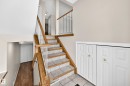Multi-level interior featuring a staircase with wood-finish handrails and white balusters - 51 9630 176 Street, Edmonton, AB 