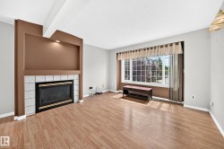 Living area featuring a tiled fireplace with an integrated display niche and recessed lighting - 