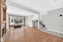 Spacious living area featuring wood-finish flooring, a large multi-pane window, and a built-in fireplace with an integrated niche - 