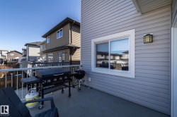 Outdoor balcony featuring gray siding and white trim around a window - 
