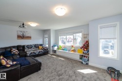 Spacious room featuring light blue walls, gray carpet flooring, and multiple windows with white blinds - 