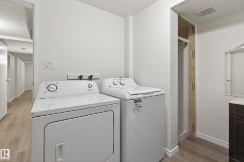 Dedicated laundry area featuring a white washing machine and dryer, light wood-finish flooring, and white walls - 156 Lee Ridge Road, Edmonton, AB - Indoor Photo Showing Laundry Room