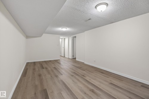 Spacious room featuring wood-finish flooring, white walls, and flush-mount ceiling lighting - 156 Lee Ridge Road, Edmonton, AB - Indoor Photo Showing Other Room